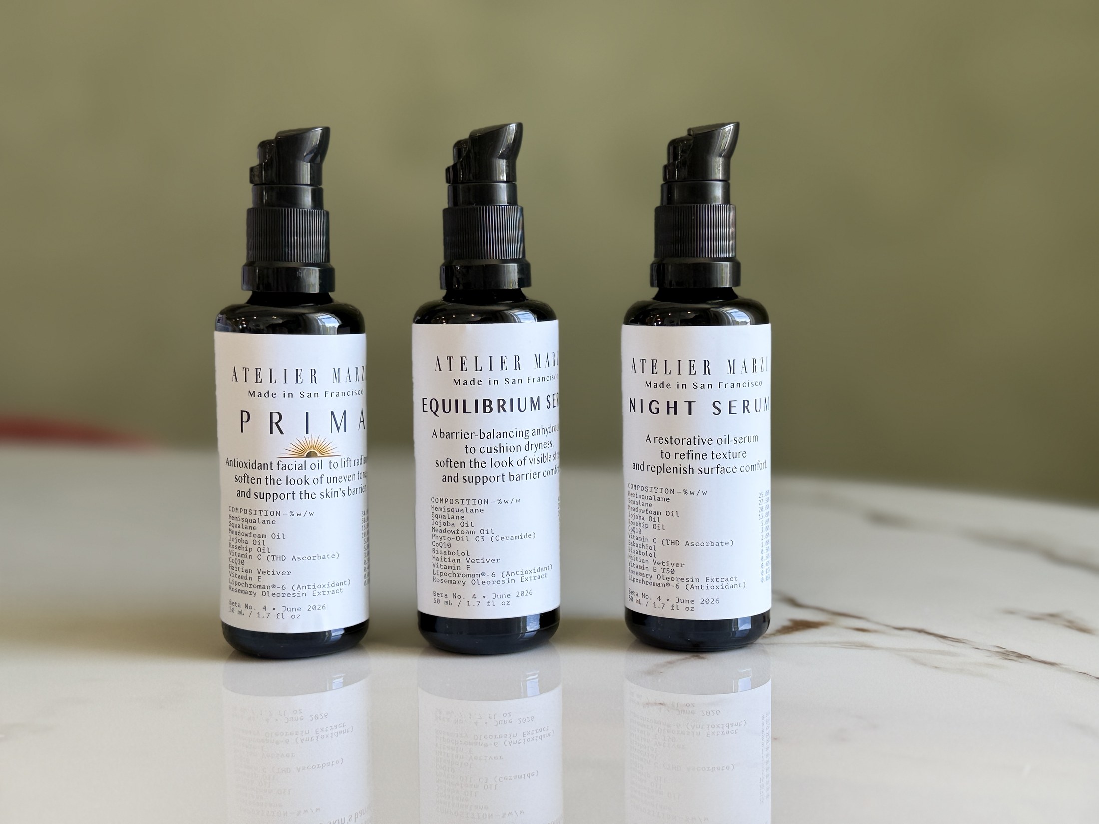 PRIMA, EQUILIBRIUM SERUM, and NIGHT SERUM bottles on a marble surface