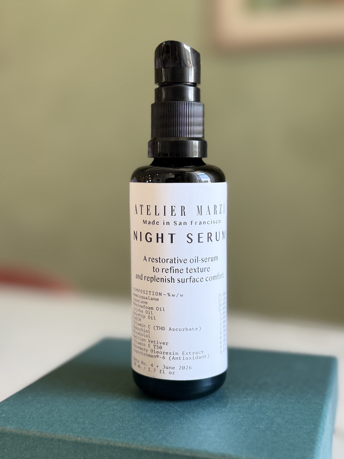 NIGHT SERUM bottle standing on a teal box